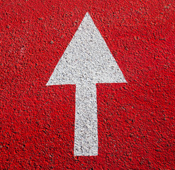 White arrow on the red asphalt surface.