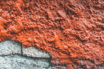 Texture of old broken red wall. Background of Wall fragment with broken stucco and bricks