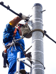 Praca montera instalacji elektrycznej na słupie energetycznym © JDziedzic