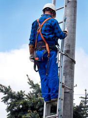 Praca montera instalacji elektrycznej na słupie energetycznym © JDziedzic