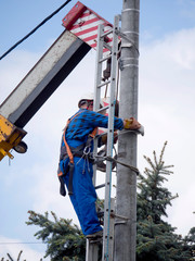 Praca montera instalacji elektrycznej na słupie energetycznym © JDziedzic