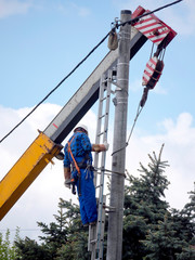 Praca montera instalacji elektrycznej na słupie energetycznym © JDziedzic