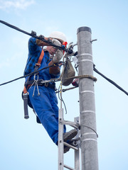 Praca montera instalacji elektrycznej na słupie energetycznym © JDziedzic