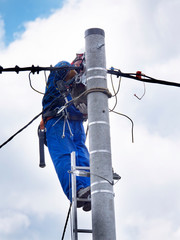 Praca montera instalacji elektrycznej na słupie energetycznym © JDziedzic