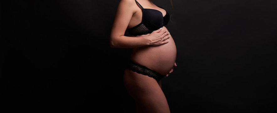 Pregnant girl on a light background. Photo without a face in the frame.