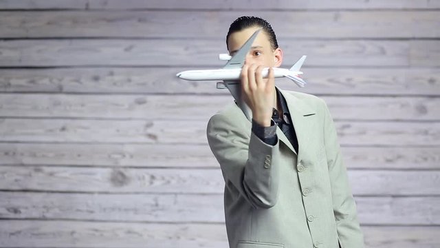 Young businessman playing with a toy plane