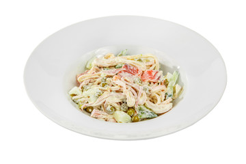 Russian salad with ham and squid, cucumber, peas, eggs, mayonnaise on plate, white isolated background, side view
