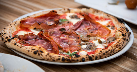 Percuitto pizza on wooden table, Italian cuisine in Vancouver, Canada