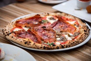 Percuitto pizza on wooden table, Italian cuisine in Vancouver, Canada