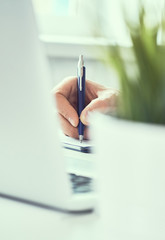 Businessman hand writing note on a notebook. Business man working at office desk. Close up of empty...