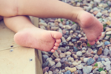 Baby's feet of a small child close-up on the pebble beach. Vacation on the Mediterranean sea