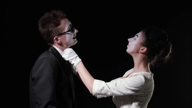 love couple mimes. girl mime in dress removes dust particles from a man mime and hugs him
