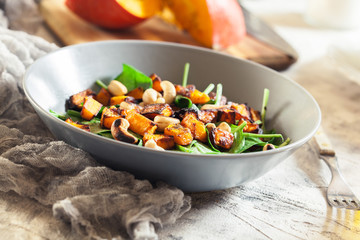 Roasted pumpkin salad with spinach and nuts