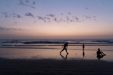 Silhouette of young boy performing stunts in front of sea