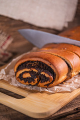 Poppy seeds roll, homemade cake on rustic wooden background