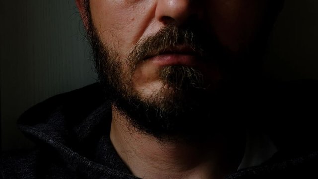 Don't speak, be quiet - close up portrait of bearded man on the door saying shhh. Finger on lips. Head and shoulders, no eyes. Danger. Violence concept.