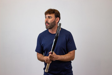 Portrait of handsome young man playing tennis holding a racket with brown hair looking jealous, facing forwards and looking at the horizon. Isolated on white background.