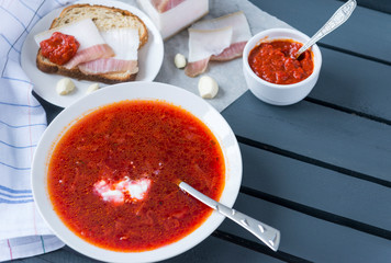 plate of borscht with sour cream, lard with bread, ketchup, soup