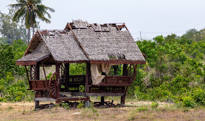 An old ramshackle hut on the edge of a green field.