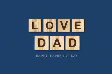 Happy father's day background. Word, Love dad written on wooden blocks. Dark background Congratulatory background.