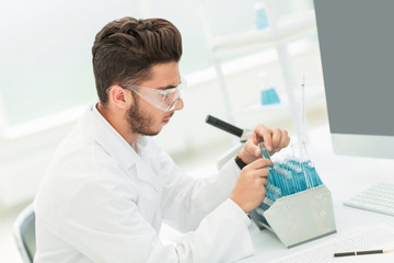 modern scientist examines test tube with liquid