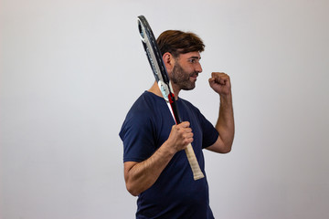 Portrait of handsome young man playing tennis holding a racket with brown hair looking with lust, facing forwards and looking at the side. Isolated on white background.