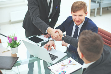 Manager's and client's handshakes over the Desk in the Bank's office