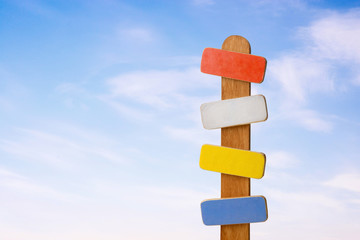 Signpost on a blue clear sky with small clouds