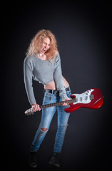 emotional rock singer with her guitar. isolated on a dark