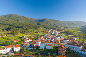 Fototapeta premium Aerial view of small town with red roofs during sunrise time. Top View of Valhelhas village in central Portugal