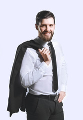 smiling businessman holding a jacket over his shoulder and straightens the tie