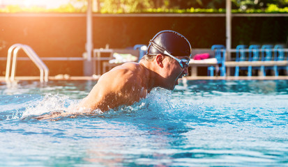 Young athletic man swimming in the swimming pool