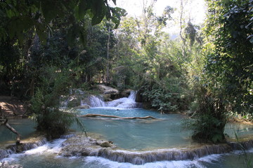 Scenic view on cascades and natural blue pool of idyllic Kuang Si waterfalls in jungle near Luang Prabang, Laos