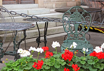 Table, chair and geranium flowers in cafe in Stokholm, Sweden