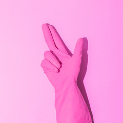 Fashion creative concept with hand in pink rubber glove, showing gesture. Symbol of way pointer. Aesthetic abstract minimalism.