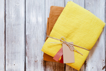 Yellow and ochre linen fabric packed with jute rope. Concept of sewing from natural textile clothing background