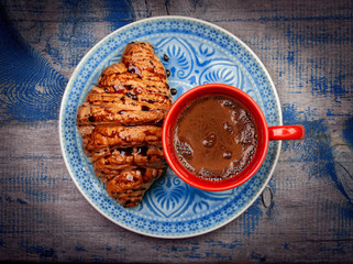 Croissant and coffee on blue wooden table