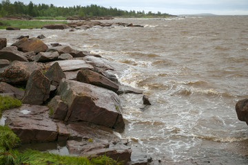 The strong waves of the White Sea crashing on the rocky shore