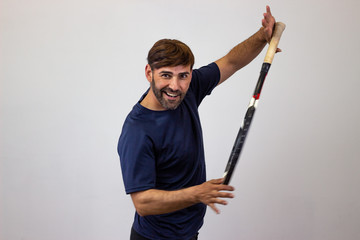 Portrait of handsome young man playing tennis holding a racket with brown hair holding a blank sign, their back facing the camera and looking at the camera. Isolated on white background.