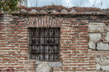 old window with wooden shutters and rusty fence on a old brick wall in a building in Madrid. Spain