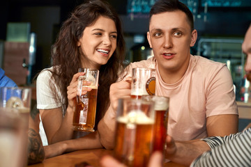 Front view of happy pair sitting together in pub