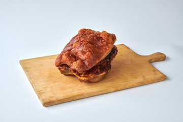 Deutscher Schweinebraten auf Holzbrett mit weißem Hintergrund 