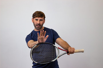 Portrait of handsome young man playing tennis holding a racket with brown hair holding an invisable object, looking at the camera. Isolated on white background.