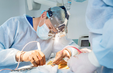 Spinal surgery. Group of surgeons in operating room with surgery equipment. Laminectomy