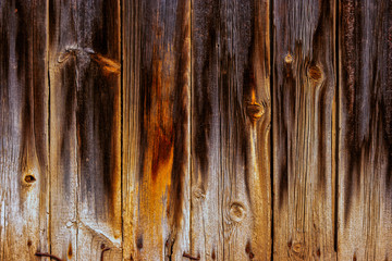 Weathered planks with footprints of fire on its surface