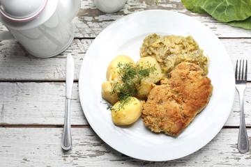 Traditional  Polish cuisine, pork chop with potatoes and fried cabbage.