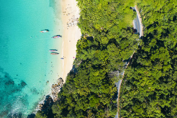 View from above, stunning aerial view of a beautiful tropical beach with white sand and turquoise clear water, long tail boats and people sunbathing, Banana beach, Phuket, Thailand. - obrazy, fototapety, plakaty