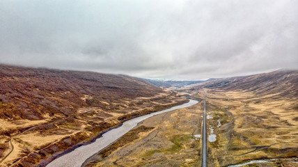 aerial photograph of a straight road near to river ans watterfallsin the north of iceland