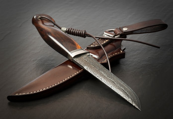 Hunting knife handmade on a black background. Leather Sheath Handmade