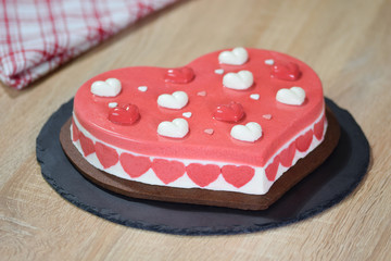 Heart shaped mousse cake. Cake in the shape of a heart on a black plate.
